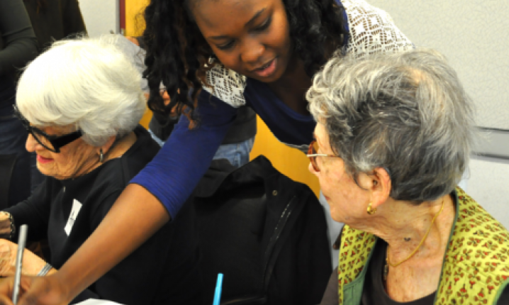 Young person writing with old person